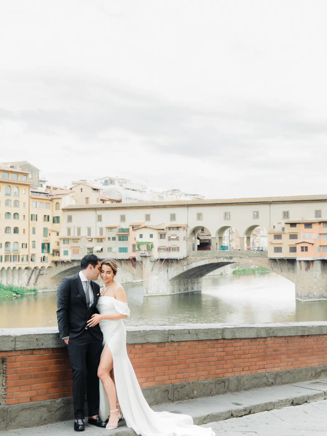 Romantic couple by the Ponte Vecchio during sunrise photosession in Florence