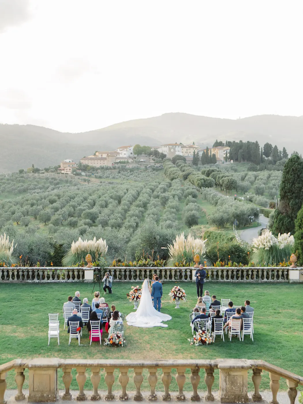 Enchanting Tuscan wedding ceremony at a medieval villa, with the bride and groom exchanging vows amidst the timeless charm of the historic architecture and rolling hills