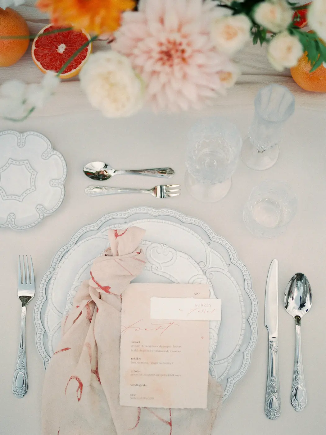 Timeless elegance of wedding table decoration with flowers, fruits and hand writing menu