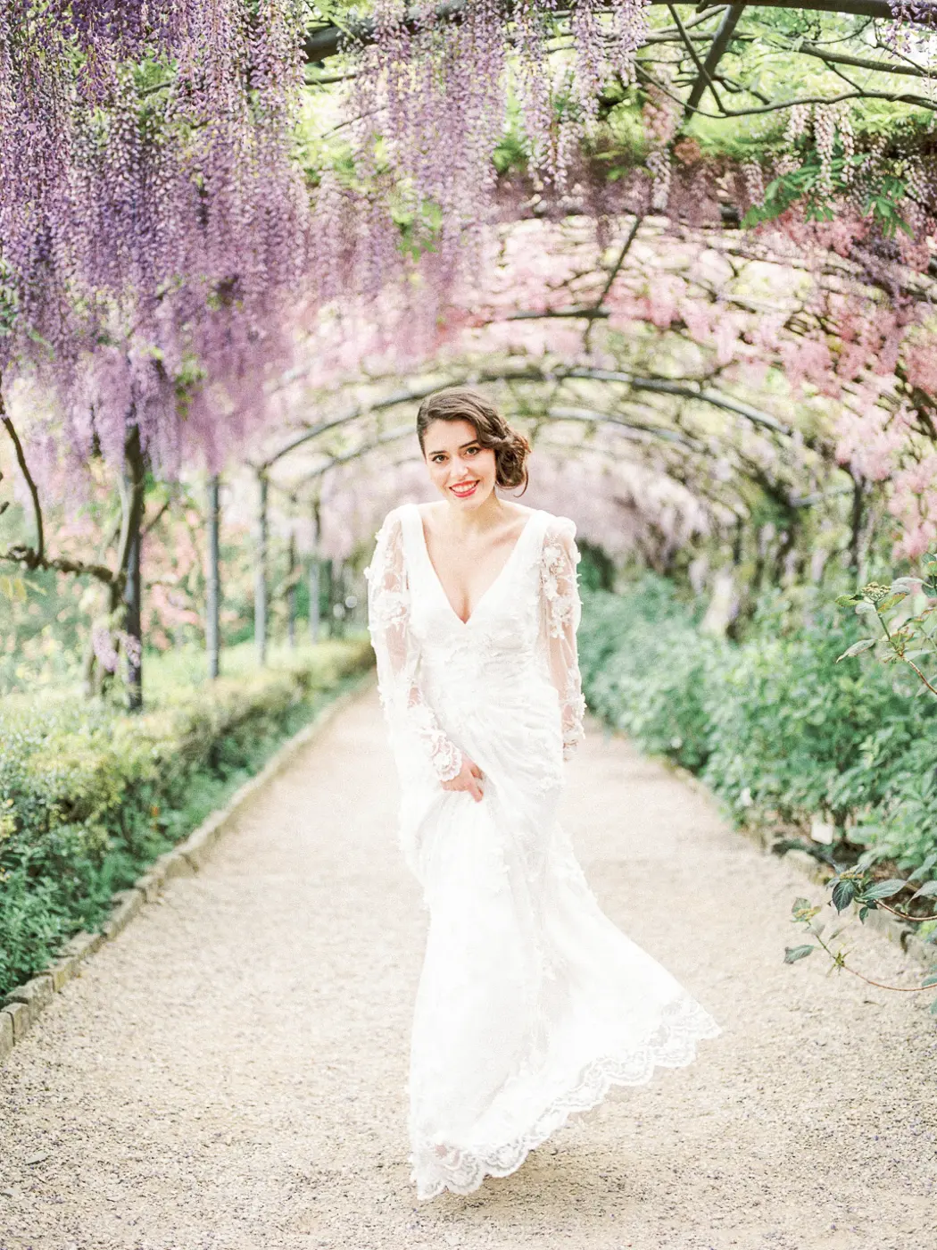 Timeless beauty in bloom: A captivating solo portrait of the bride framed by cascading wisteria, the delicate blooms complementing her grace and radiance on this special day in Florence
