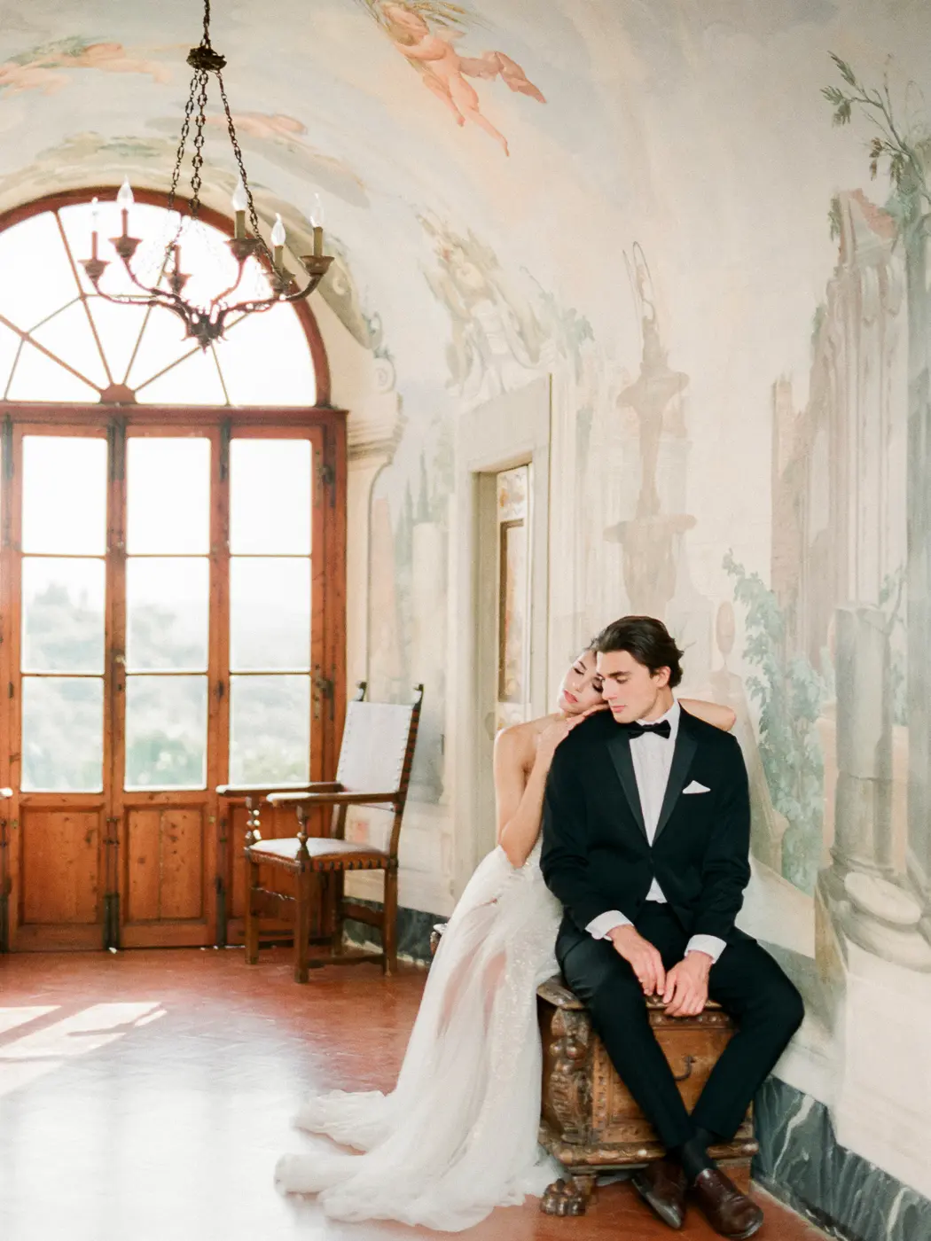 A candid moment of the newlyweds hugs at the luxury medieval villa with frescoes on the walls