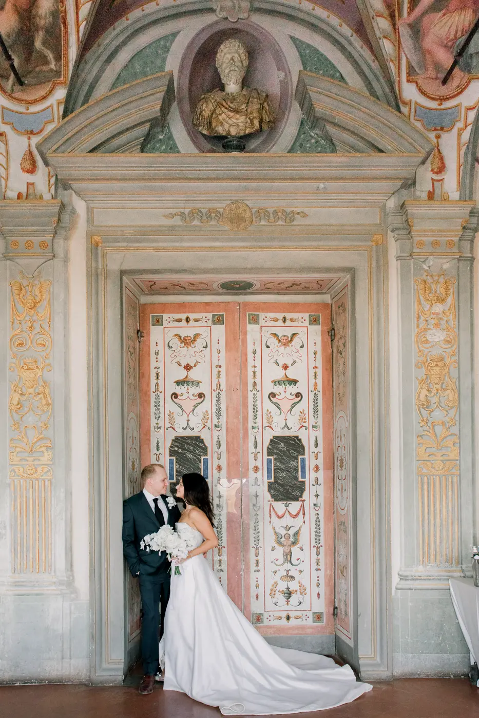 Groom and bride in front of the old door with frescoes